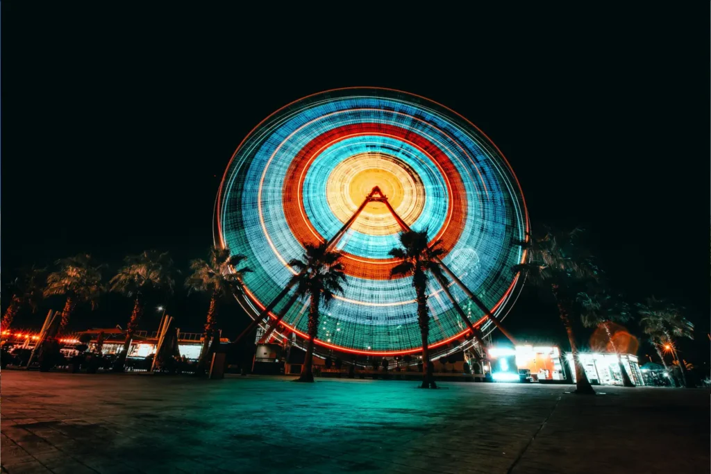 Imagem do Orlando Eye iluminado à noite, um dos pontos turísticos em Orlando.