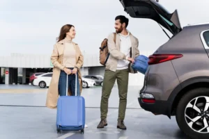 Casal com malas no veículo, reforçando a importância de entender os requisitos para alugar carro no exterior.